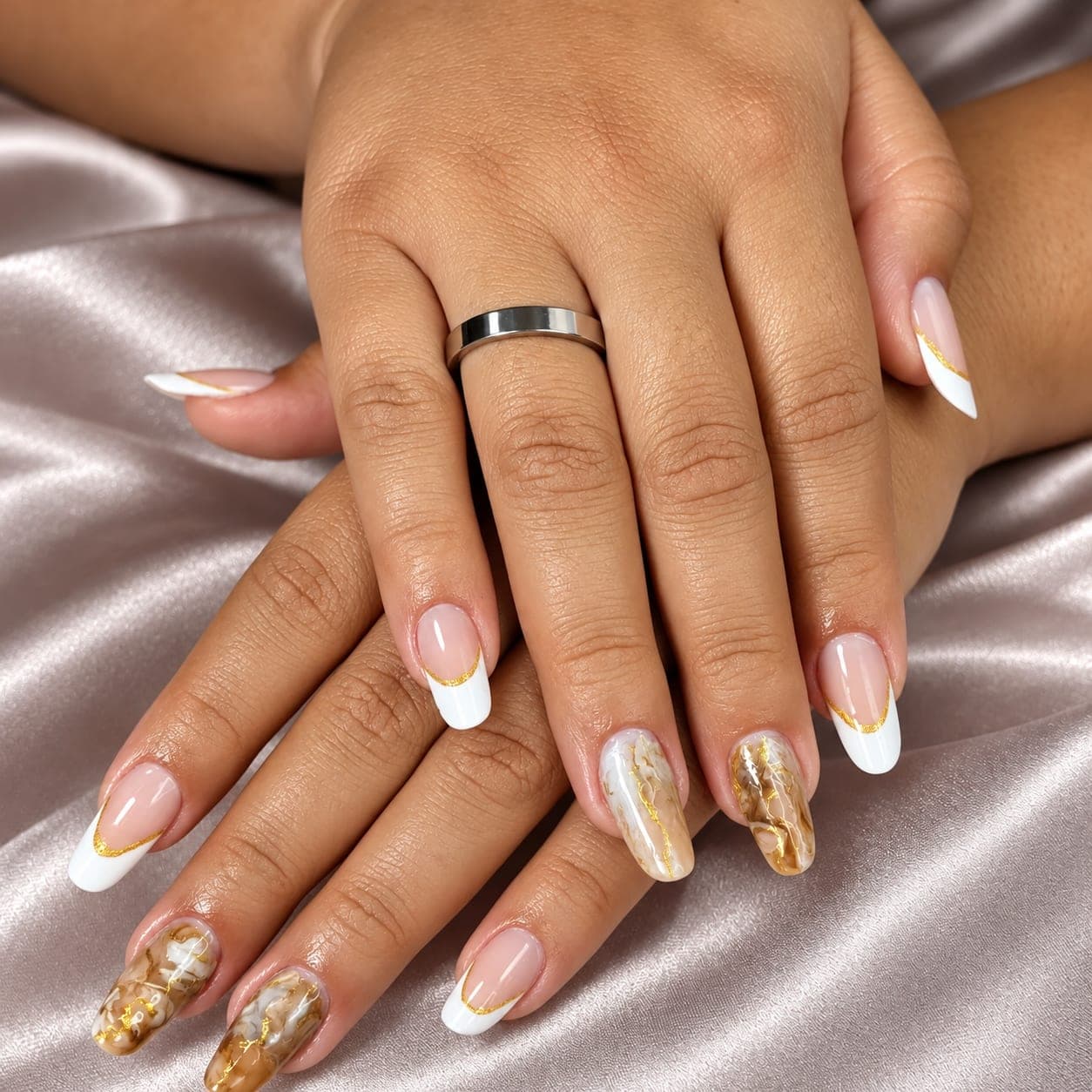 Unhas em gel com francesinha branca, fios dourados e efeito mármore dourado sobre cetim